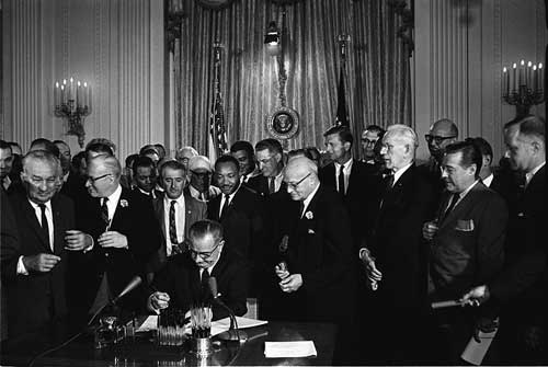 President Lyndon Johnson signing Civil Rights Bill as Martin Luther King looks on.  Source: Wikimedia Commons