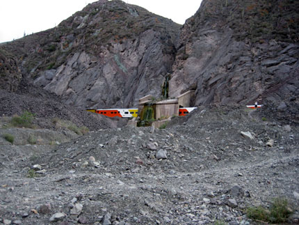 Train going through small tunnel built to have water diverted over tracks