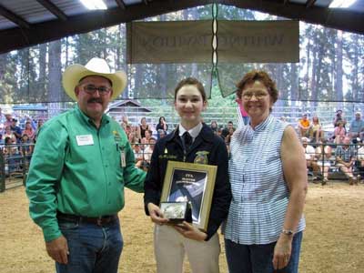 Shelby McClelland accepts a master showmanship award from Tom Browning, a member of the Nevada County Fairgrounds Board of Directors, and Wanda Mertens